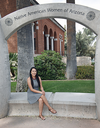 Photo of Morgan sitting by Native American Women statue