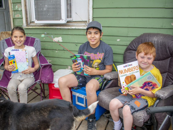 A photo of Marnie, Braxton and John Jr holding school supplies.