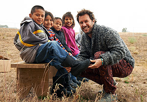 Founder Blake Mycoskie fits a Navajo youth for TOMS Shoes
