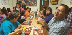 Native American people eating Thanksgiving dinner.