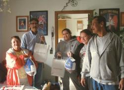 Native American people receiving items for Thanksgiving dinner.