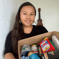 A photo of student holding a care package.